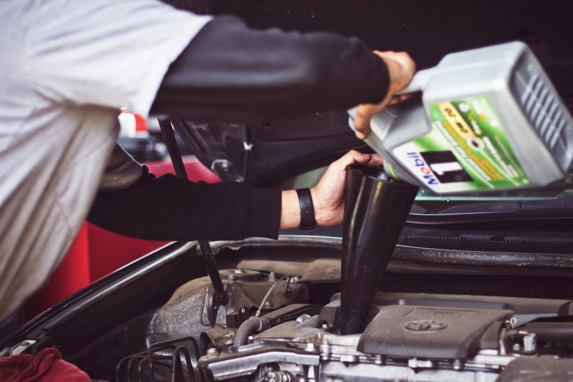 tim-mossholder-V37iTrYZz2E-unsplash Man refilling motor oil on car engine bay